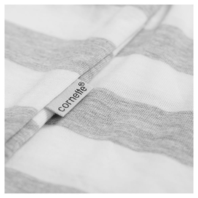 Metka Cornette naszyta na białoszare paski materiału bluzy piżamowej.