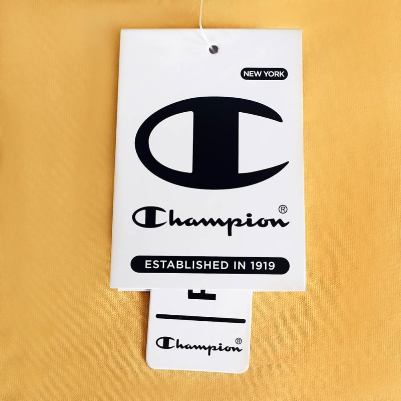 Zbliżenie na metkę na żółtej koszulce damskiej Champion