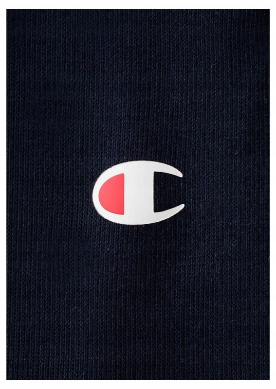 Zbliżenie na logo granatowych spodni dresowych Champion