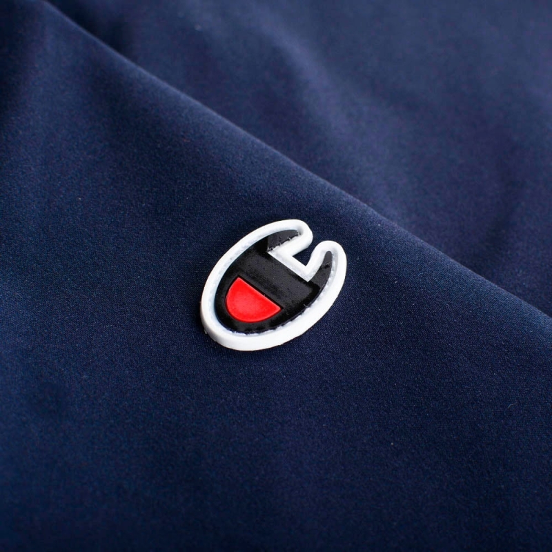 Logo Champion na rękawie granatowej kurtki