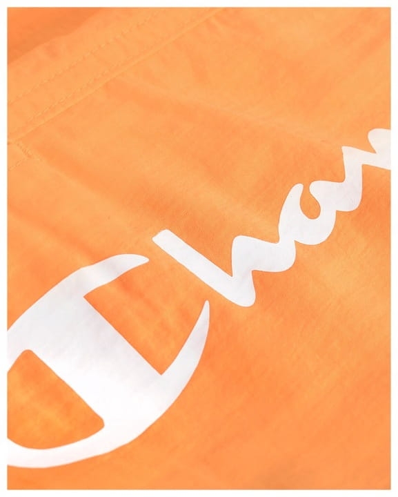 Zbliżenie na białe logo na pomarańczowych kąpielówkach męskich Champion