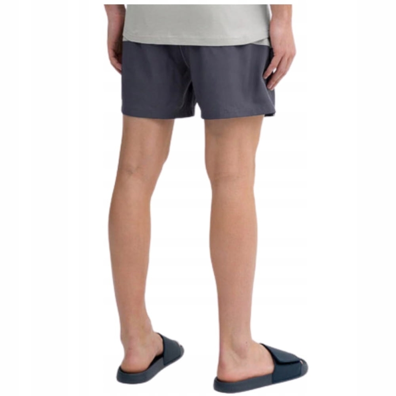 Męskie spodenki kąpielowe 4F miętowe prezentowane na modelu.