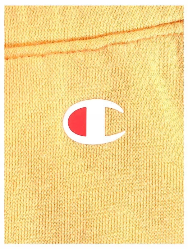Zbliżenie na logo na ciemno żółtych spodniach dresowych Champion