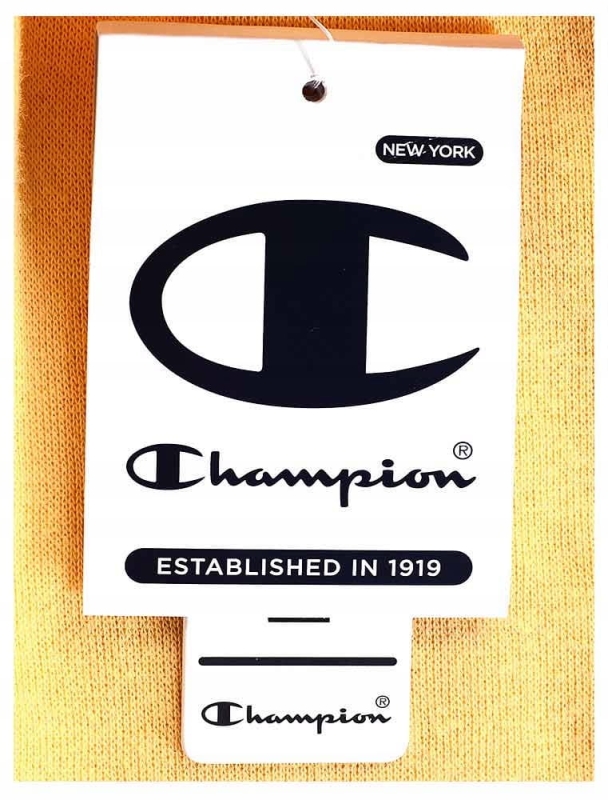 Zbliżenie na metkę na ciemno żółtych spodniach dresowych Champion