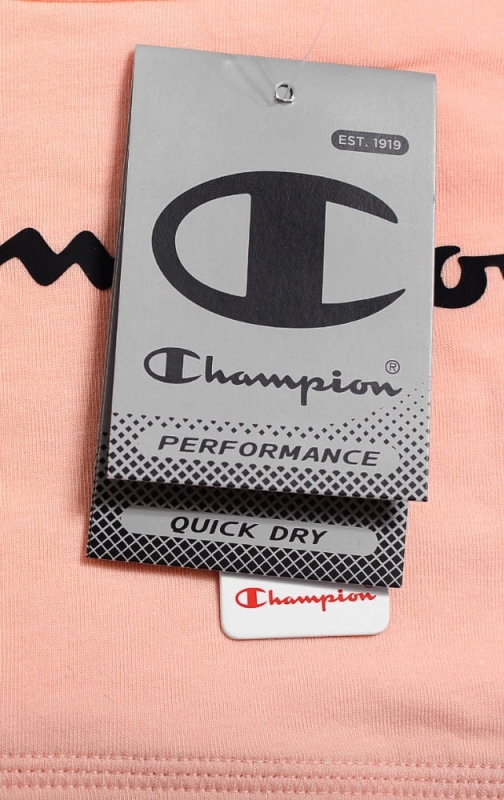 Zbliżenie na metkę brzoskwiniowego topu sportowego Champion