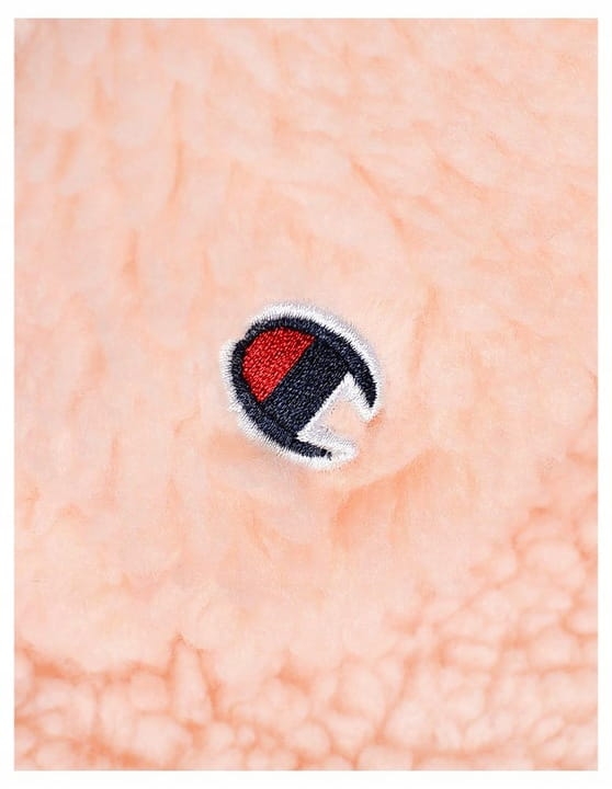 Zbliżenie na logo pudrowej bluzy polarowej damskiej champion