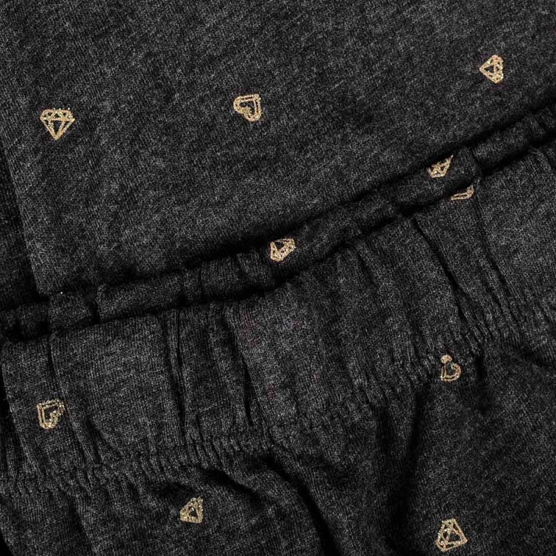 Detal wzoru złotych serc i diamentów na spodniach