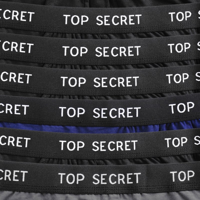 Zbliżenie na elastyczną gumę bokserek TOP SECRET z kontrastowym logo.