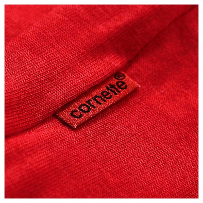 Czerwona metka z logo Cornette na materiale piżamowym.