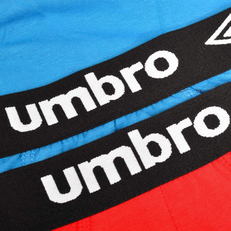 Zbliżenie gumy z logo Umbro na kolorowych bokserkach męskich.