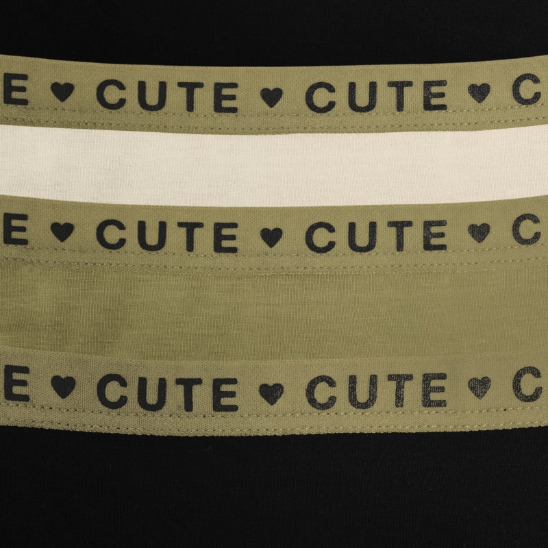 Zbliżenie elastycznej gumki z napisem CUTE w trzech kolorach