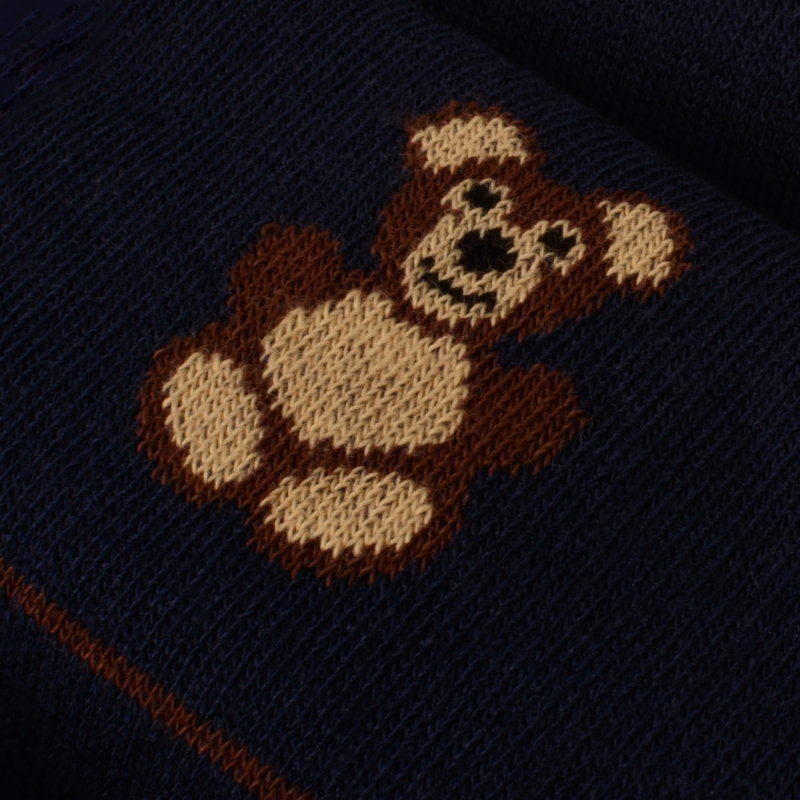 Zbliżenie na wzór misia na granatowej tkaninie – widoczne detale dzianiny.