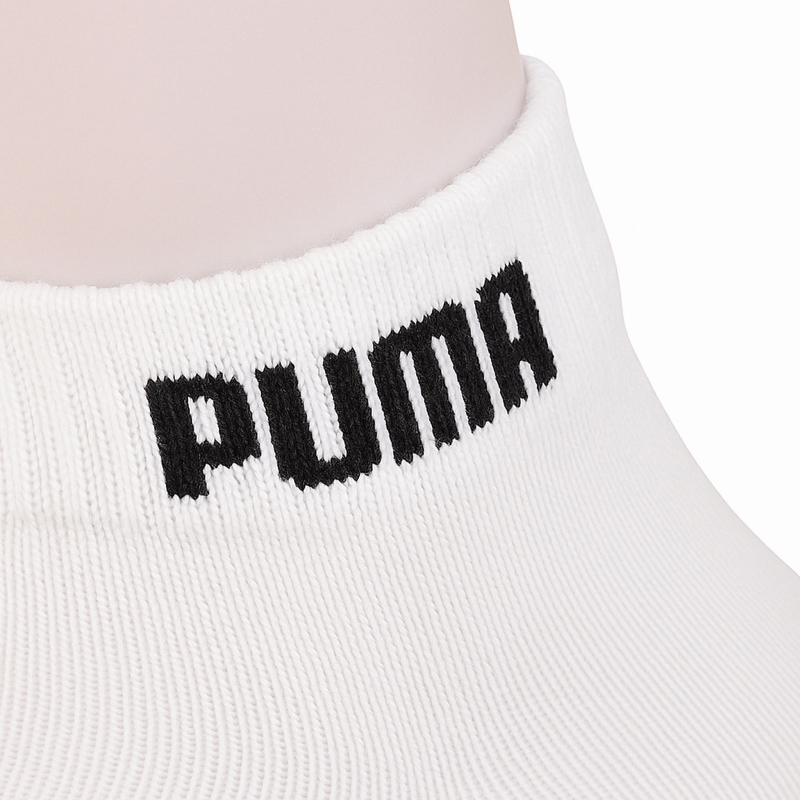 Zbliżenie na elastyczny ściągacz białych skarpet Puma.