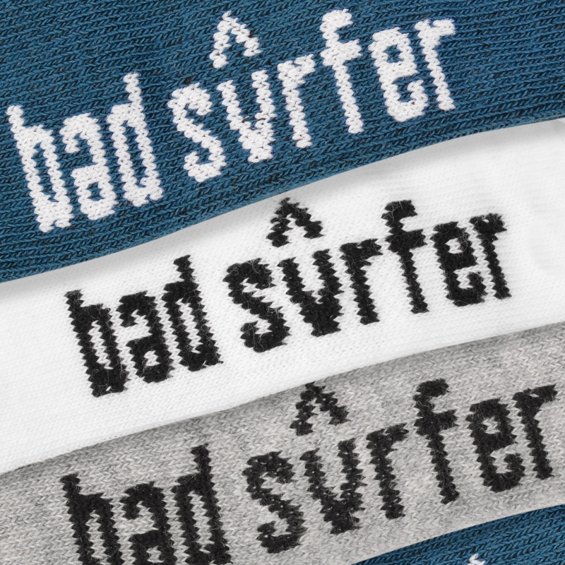 Logotyp Bad Surfer na stopkach w kolorach: granatowy, biały i szary