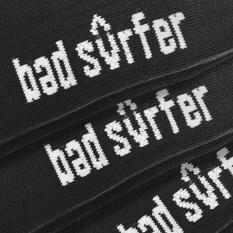 Biały nadruk „bad surfer” na czarnych stopkach – zbliżenie