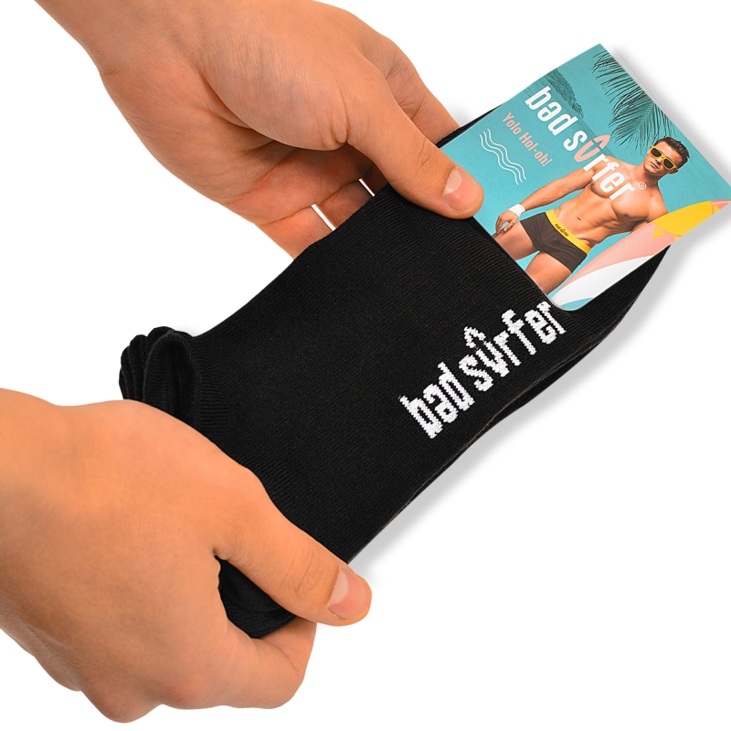 Czarne stopki Bad Surfer w dłoniach – widoczne opakowanie z grafiką