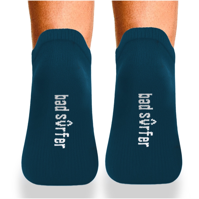 Granatowe stopki Bad Surfer – widok od spodu na stopach z białym haftowanym logo