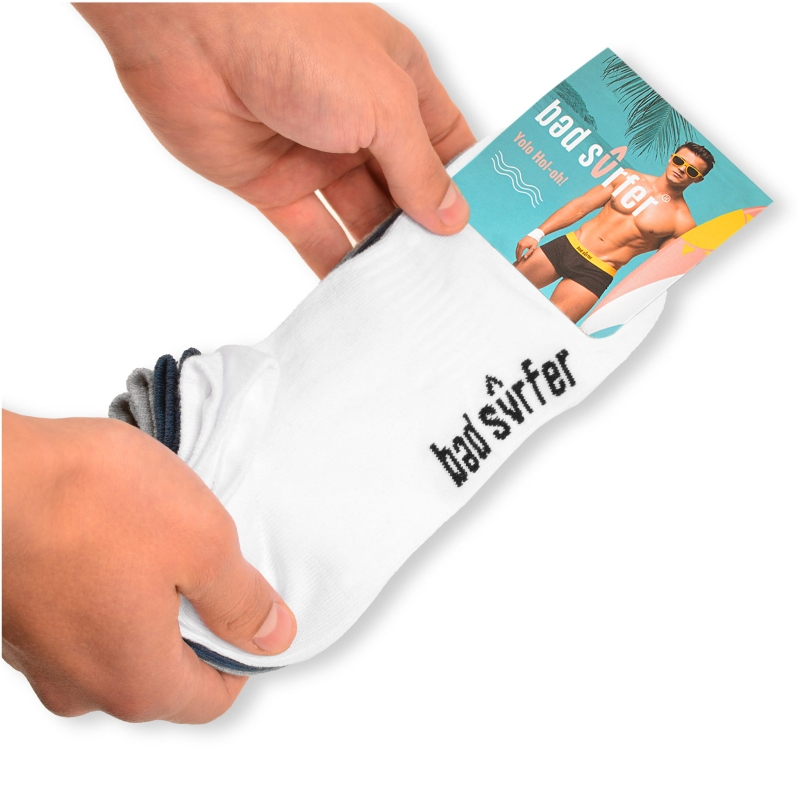 Białe stopki Bad Surfer z opakowaniem – prezentacja w dłoni