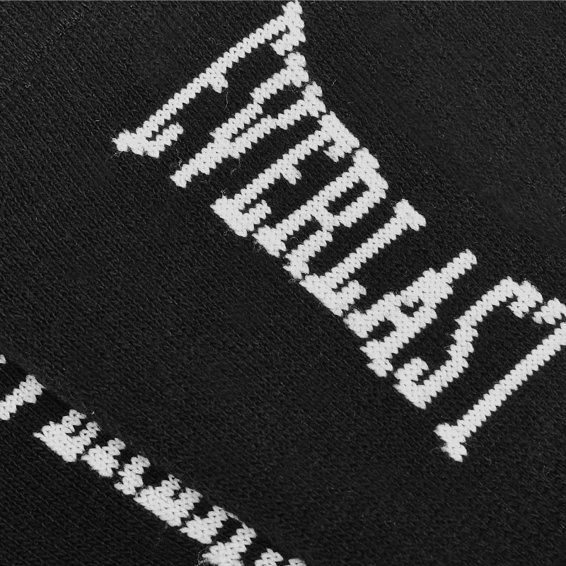 Zbliżenie na biały napis EVERLAST na czarnej powierzchni skarpetki.