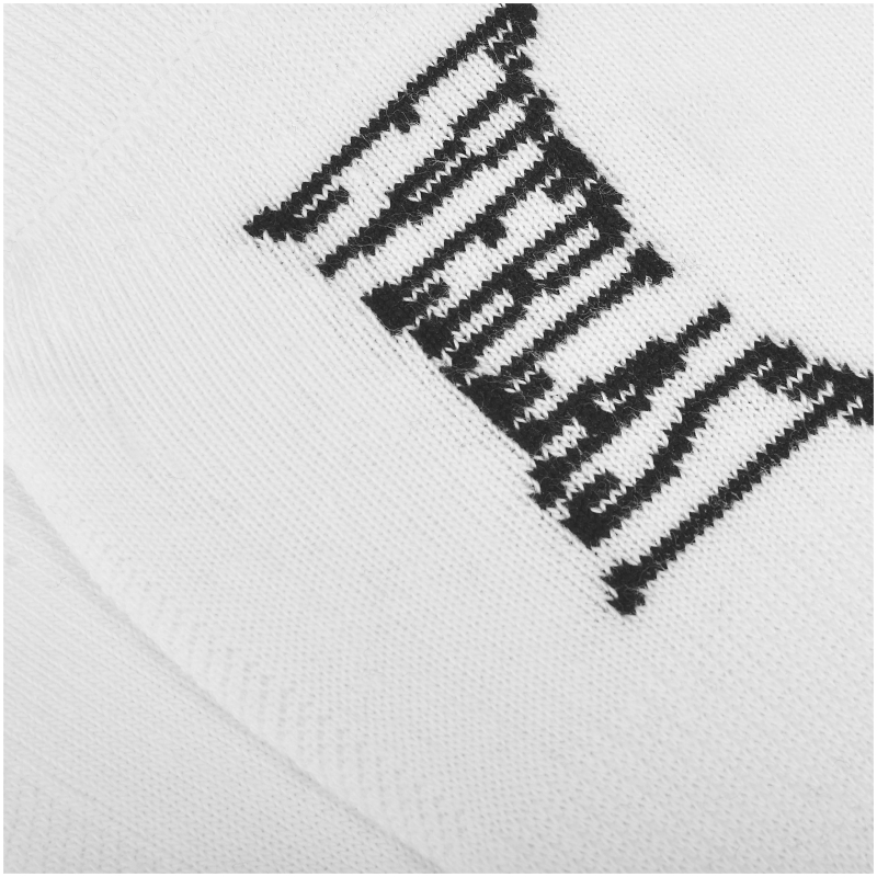 Zbliżenie na czarny napis EVERLAST na białej powierzchni skarpetki.