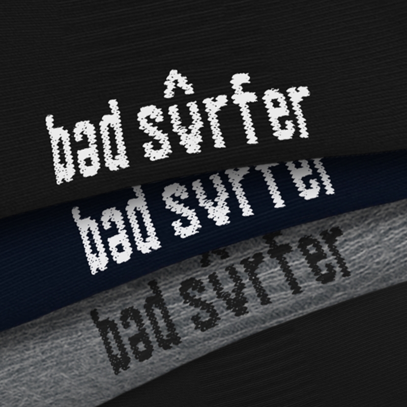 Logo Bad Surfer pod stopą – zbliżenie haftu
