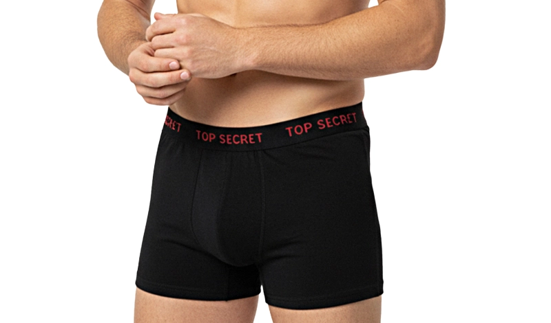 Model w czarnych bokserkach Top Secret z czerwonym napisem na gumie