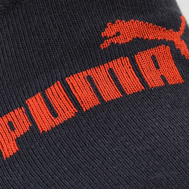 Zbliżenie czerwonego logo PUMA na granatowej dzianinie