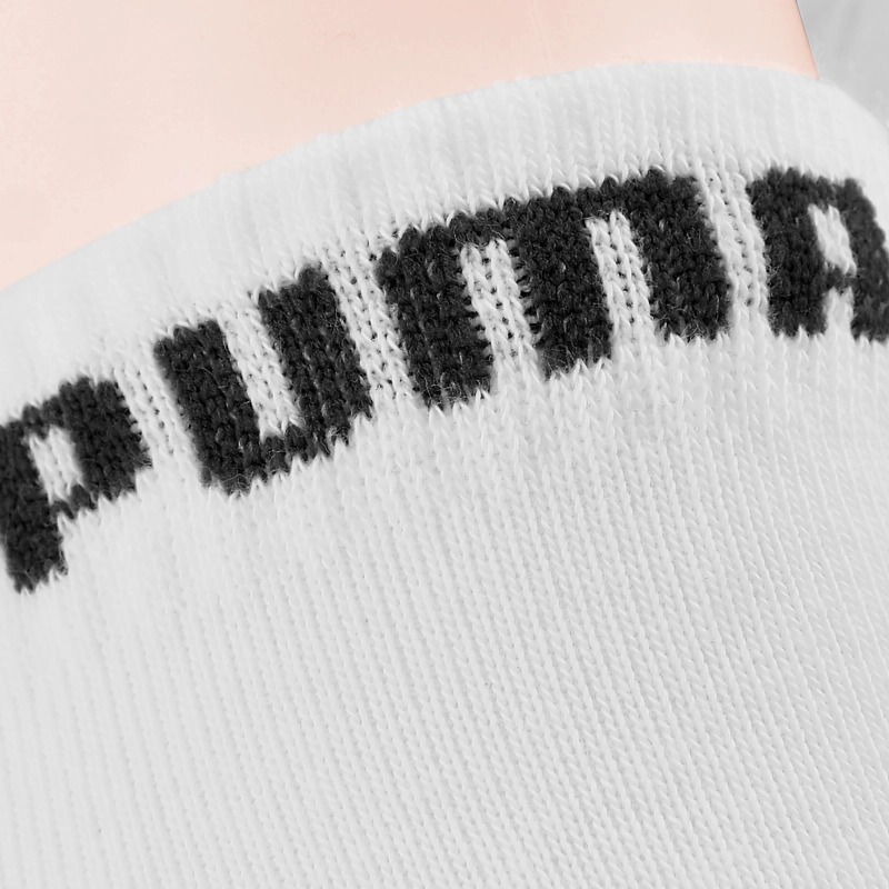 Zbliżenie czarnego napisu PUMA na białym ściągaczu skarpety