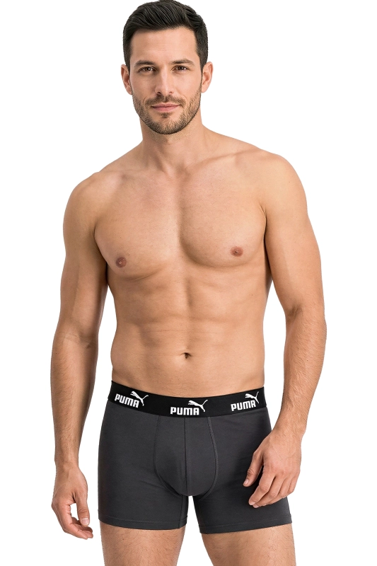 Model prezentujący czarne bokserki PUMA z zielonym pasem.